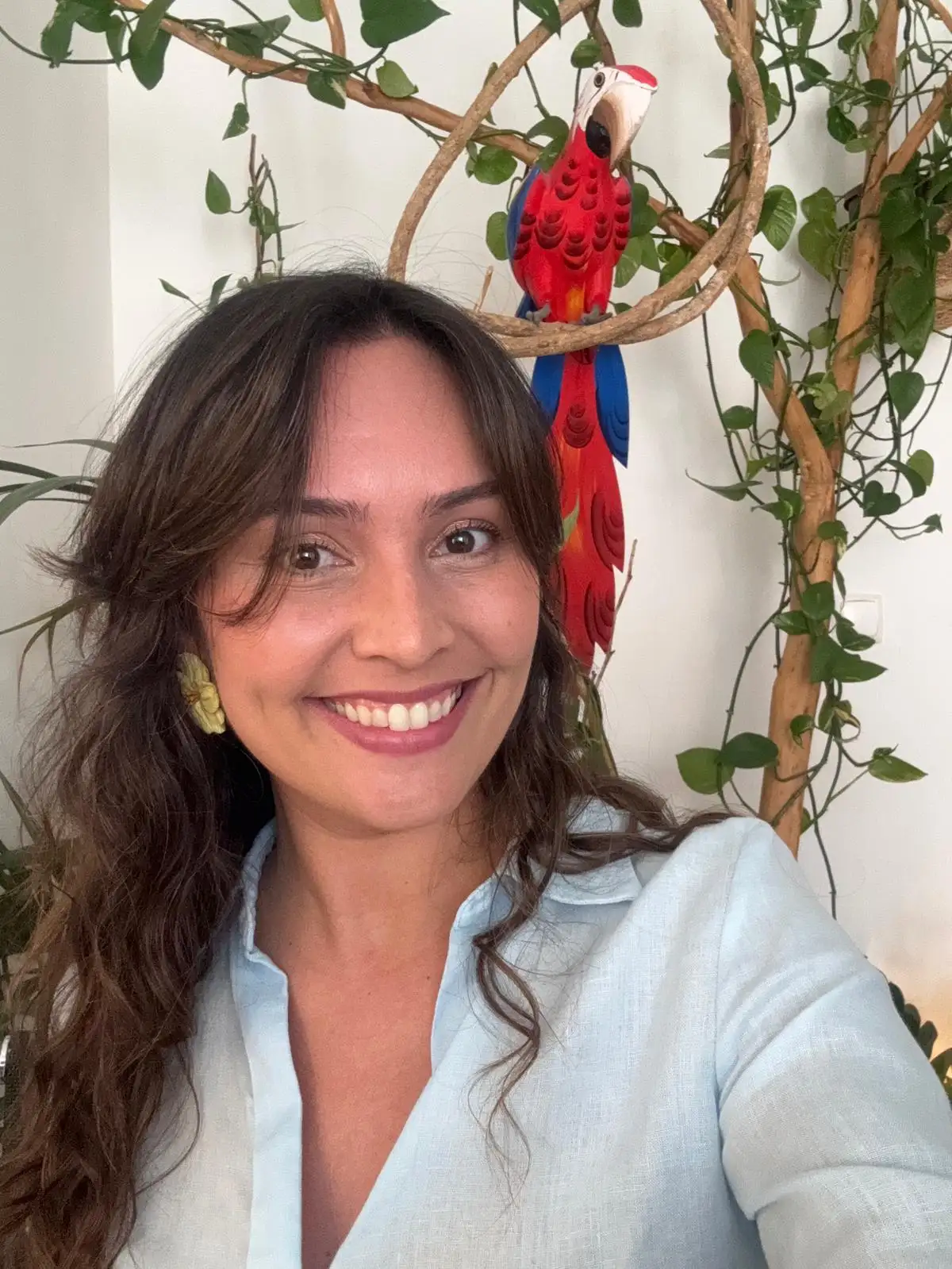 Image of Brazilian Portuguese as a foreign language teacher Bárbara Sousa. A teacher who has been teaching Portuguese for over 7 years. She is in her office, where she has a tropical setting and works with great dedication to teach her students and make them fluent.